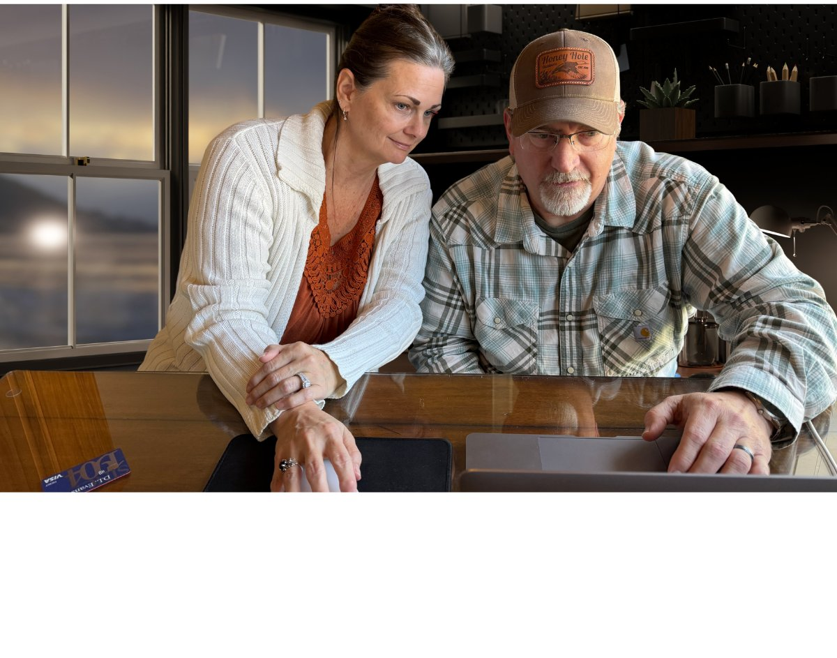 Troy and Suz Hooper reviewing a client financial timeline at their desk